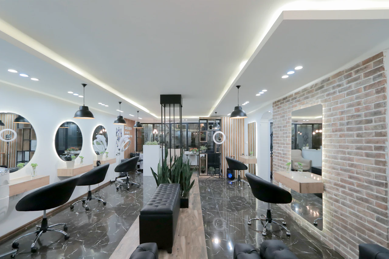 Salão do atelier com espelhos redondos e cadeiras